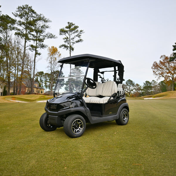 Black Club Car Tempo golf cart on a golf course with trees and houses in the background