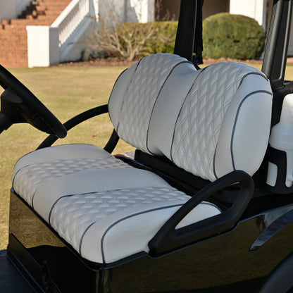 Golf cart interior with white seats on a golf course